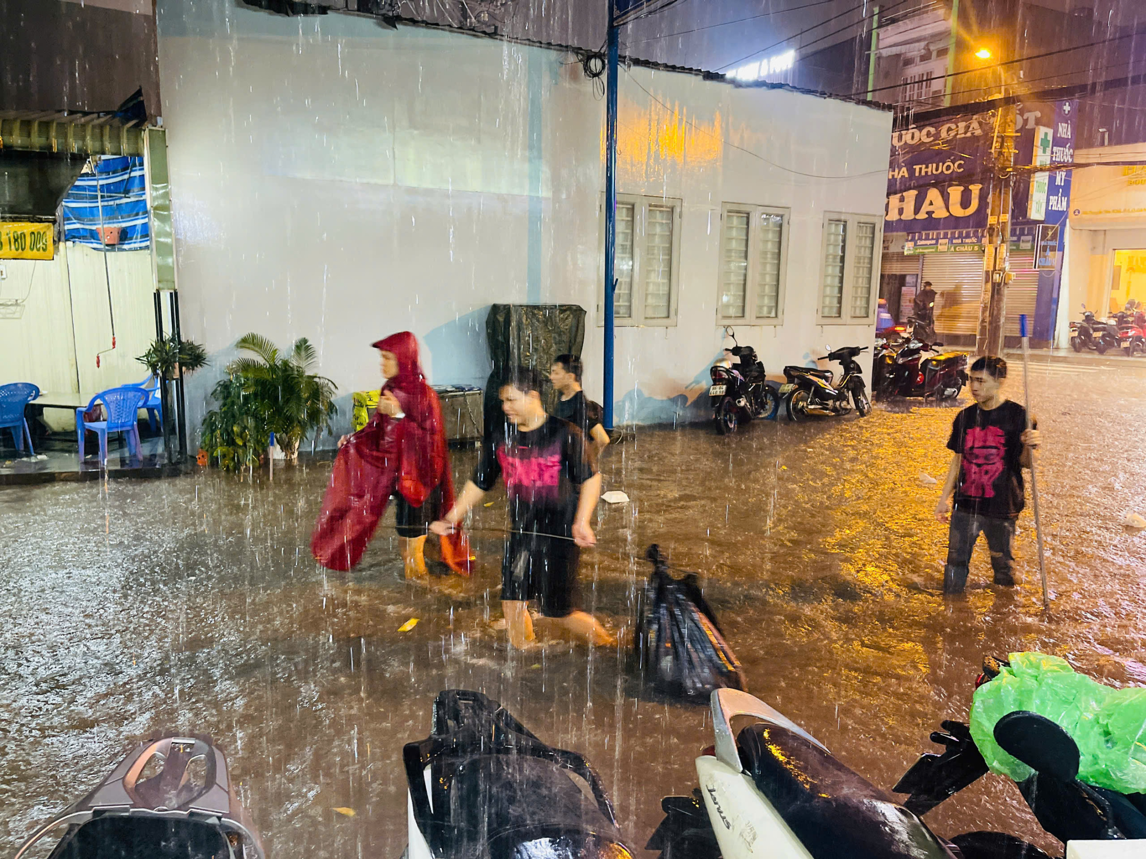 胡志明市全市大雨,旧平盛区积水严重,居民将车辆抬出积水区